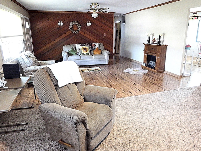 5082 Sutherland Dr, Columbus, OH 43207 - living area featuring ornamental molding, a ceiling fan, wood finished floors, wood walls, and a fireplace