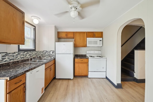 147 Schultz Ave, Columbus, OH 43222 - kitchen with white appliances, light wood-style floors, a ceiling fan, tasteful backsplash, and brown cabinets