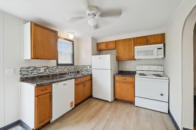 147 Schultz Ave, Columbus, OH 43222 - kitchen featuring white appliances, a ceiling fan, light wood-type flooring, dark countertops, and decorative backsplash