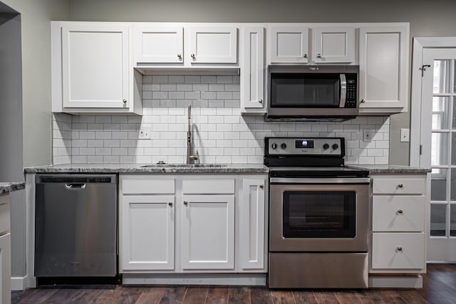 955 E Mound St, Columbus, OH 43205 - kitchen with stainless steel appliances, a sink, white cabinetry, and light stone countertops