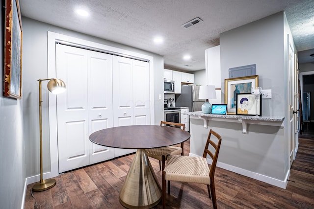 955 E Mound St, Columbus, OH 43205 - dining space with baseboards, dark wood-style flooring, a textured ceiling, and recessed lighting