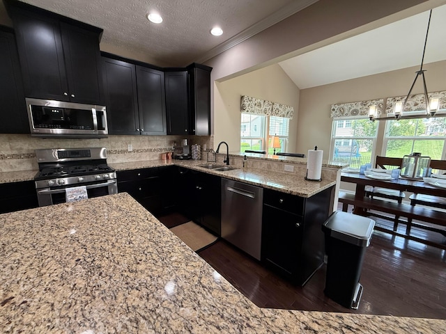 150 Shawnee Dr, Pickerington, OH 43147 - kitchen featuring appliances with stainless steel finishes, dark cabinetry, a sink, light stone counters, and tasteful backsplash