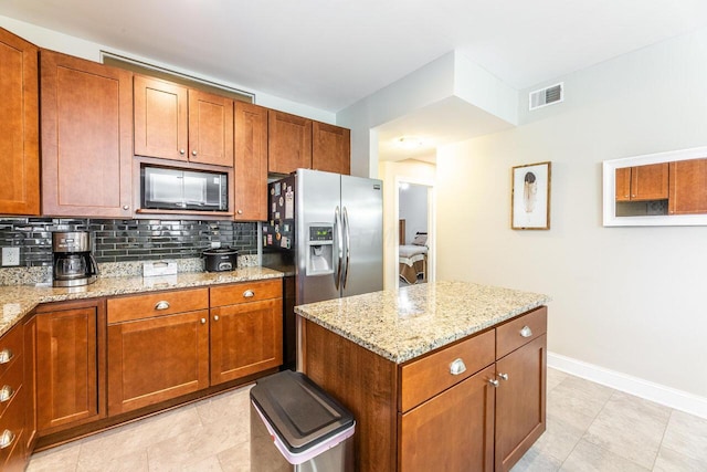 10 E Weber Rd Unit 205, Columbus, OH 43202 - kitchen featuring black microwave, tasteful backsplash, brown cabinetry, and light stone counters