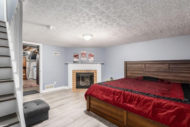 7306 Cimmaron Sta, Columbus, OH 43235 - bedroom with wood finished floors, a textured ceiling, a fireplace, and baseboards