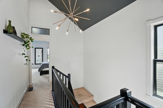 158 Punta Aly, Columbus, OH 43201 - hall featuring an upstairs landing, high vaulted ceiling, light carpet, a chandelier, and baseboards