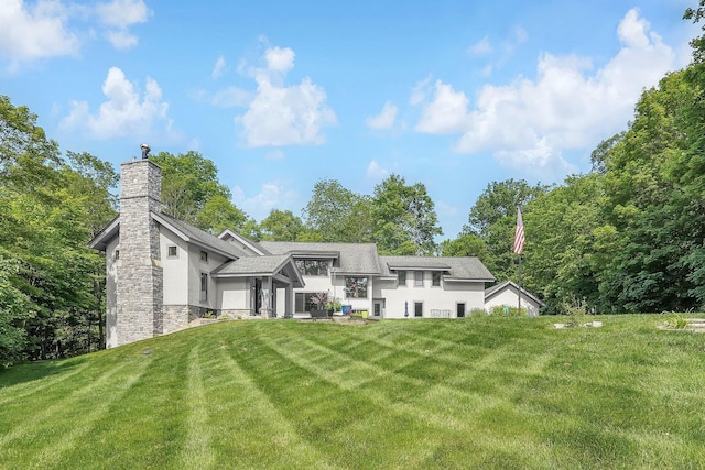 3850 Alward Rd SW, Pataskala, OH 43062 - back of property featuring stucco siding, a lawn, a chimney, and stone siding