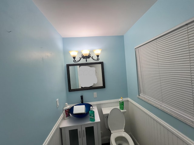 5340 Edgeview Rd, Columbus, OH 43207 - half bath featuring a chandelier, a wainscoted wall, toilet, and vanity