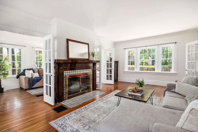 320 Rhoads Ave, Columbus, OH 43205 - living area with wood finished floors, ornamental molding, a tiled fireplace, baseboards, and french doors