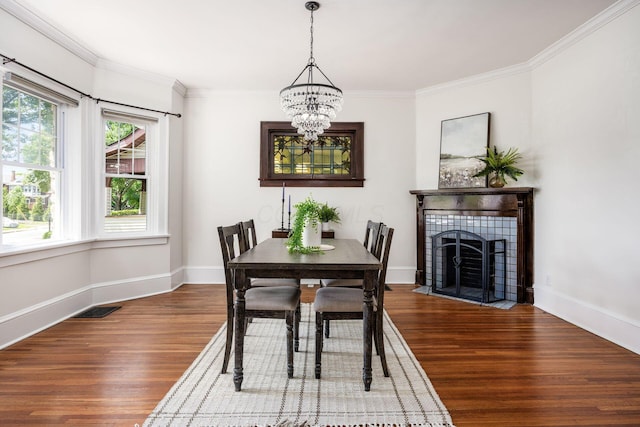 320 Rhoads Ave, Columbus, OH 43205 - dining area featuring wood finished floors, ornamental molding, a chandelier, baseboards, and a tiled fireplace
