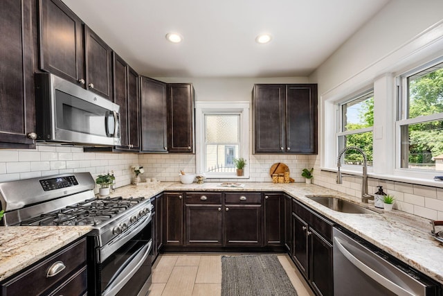 320 Rhoads Ave, Columbus, OH 43205 - kitchen featuring appliances with stainless steel finishes, a sink, backsplash, light stone counters, and recessed lighting