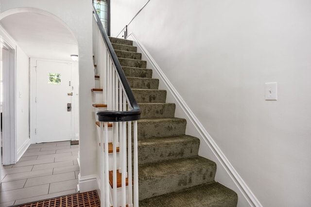 320 Rhoads Ave, Columbus, OH 43205 - staircase featuring arched walkways, baseboards, and tile patterned flooring