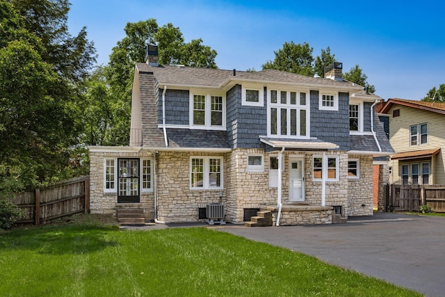 320 Rhoads Ave, Columbus, OH 43205 - view of front facade featuring a chimney, entry steps, stone siding, cooling unit, and a shingled roof