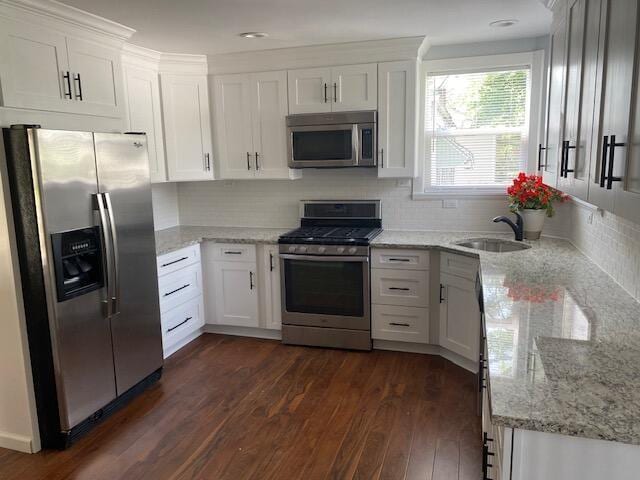 2691 Howey Rd, Columbus, OH 43211 - kitchen featuring appliances with stainless steel finishes, a sink, dark wood-style flooring, light stone counters, and white cabinetry