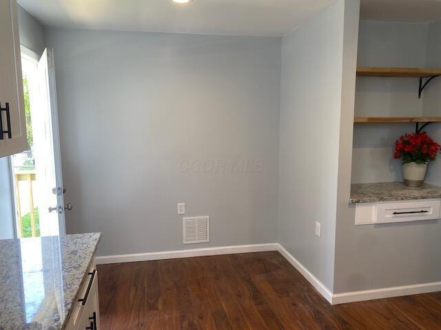 2691 Howey Rd, Columbus, OH 43211 - unfurnished dining area featuring dark wood-style floors and baseboards