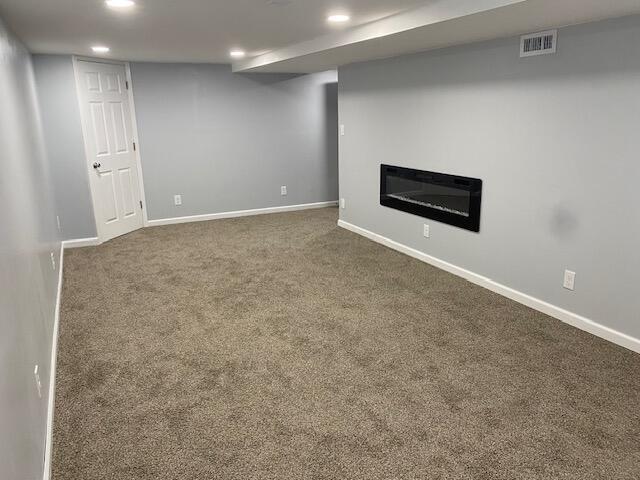2691 Howey Rd, Columbus, OH 43211 - finished below grade area featuring dark colored carpet, recessed lighting, a glass covered fireplace, and baseboards