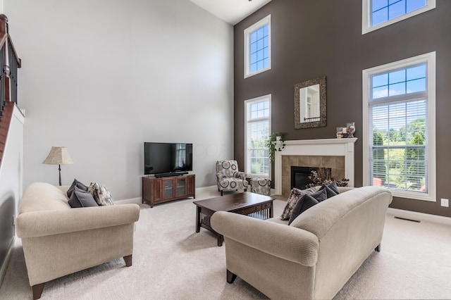 7685 Skarlocken Grn, New Albany, OH 43054 - living area featuring a tiled fireplace, a towering ceiling, and carpet flooring