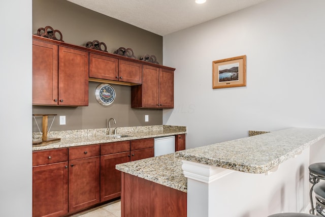 7685 Skarlocken Grn, New Albany, OH 43054 - kitchen featuring a breakfast bar, light stone countertops, a peninsula, dishwasher, and a textured ceiling