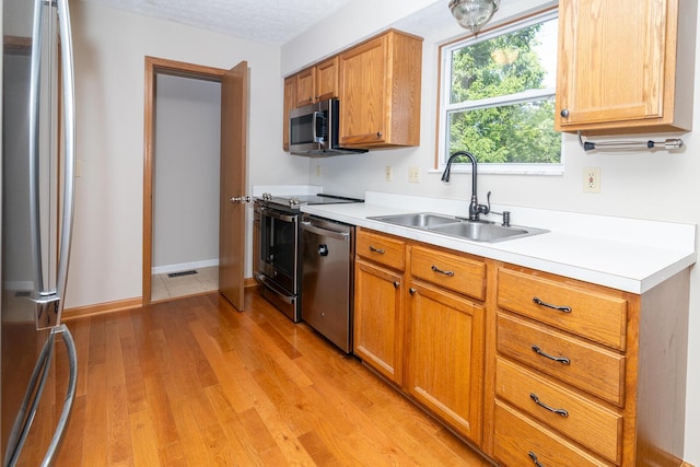 3476 Bayspirit Ct, Reynoldsburg, OH 43068 - kitchen with stainless steel appliances, light countertops, light wood finished floors, and brown cabinets