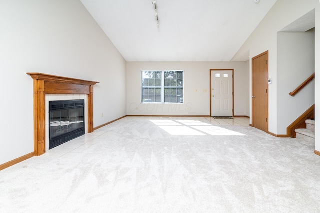 3476 Bayspirit Ct, Reynoldsburg, OH 43068 - unfurnished living room with lofted ceiling, carpet flooring, stairs, a fireplace, and track lighting