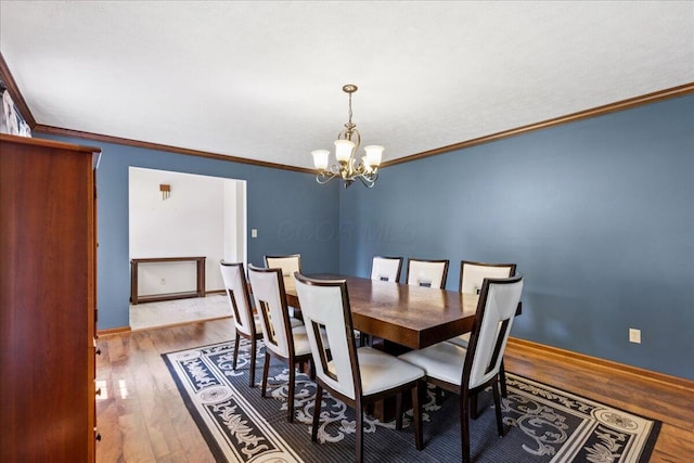 685 Hawthorne Dr, Circleville, OH 43113 - dining room with wood finished floors, a chandelier, crown molding, and baseboards