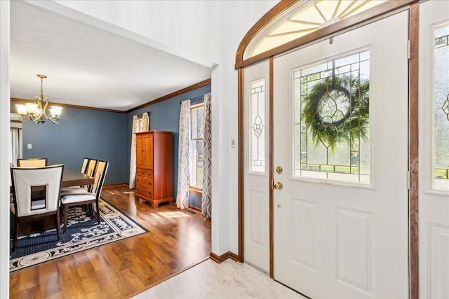 685 Hawthorne Dr, Circleville, OH 43113 - foyer featuring a chandelier, ornamental molding, wood finished floors, and baseboards