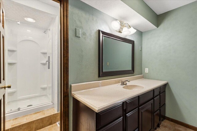 685 Hawthorne Dr, Circleville, OH 43113 - bathroom featuring a stall shower, vanity, baseboards, tile patterned flooring, and a textured wall