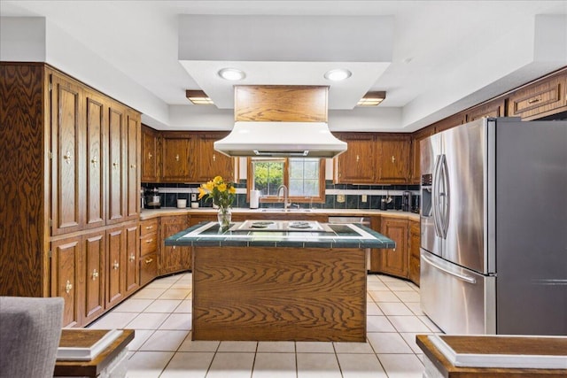 685 Hawthorne Dr, Circleville, OH 43113 - kitchen with stainless steel refrigerator with ice dispenser, extractor fan, tile counters, a kitchen island, and decorative backsplash