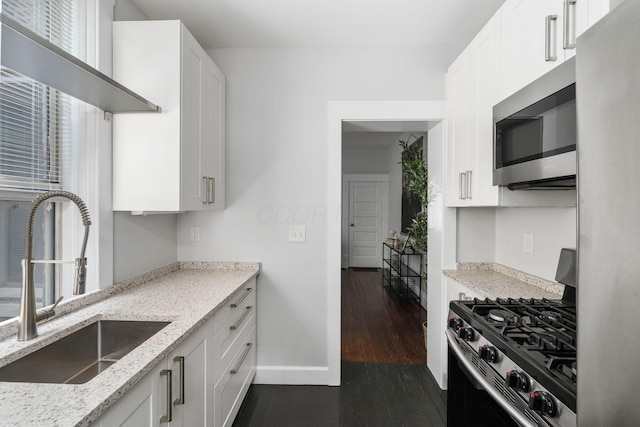 994 Delaware Ave, Columbus, OH 43201 - kitchen featuring stainless steel appliances, a sink, white cabinets, and light stone counters