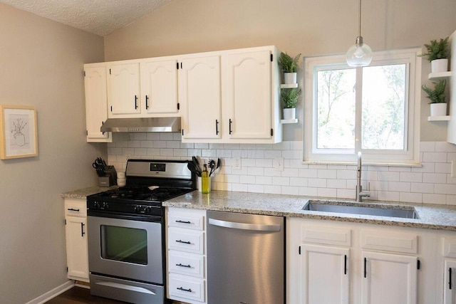 1771 Redcloud Dr, Powell, OH 43065 - kitchen featuring appliances with stainless steel finishes, under cabinet range hood, a sink, white cabinetry, and lofted ceiling