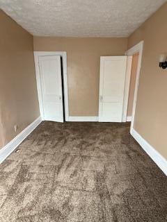 863 E Whittier St, Columbus, OH 43206 - unfurnished bedroom with baseboards, carpet floors, a textured ceiling, and a closet