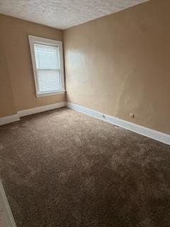 863 E Whittier St, Columbus, OH 43206 - carpeted empty room with baseboards and a textured ceiling