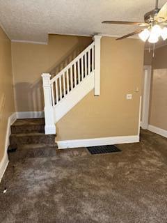 863 E Whittier St, Columbus, OH 43206 - unfurnished living room featuring stairway, baseboards, a ceiling fan, carpet, and a textured ceiling
