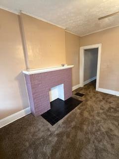 863 E Whittier St, Columbus, OH 43206 - unfurnished living room with baseboards, carpet, and a fireplace