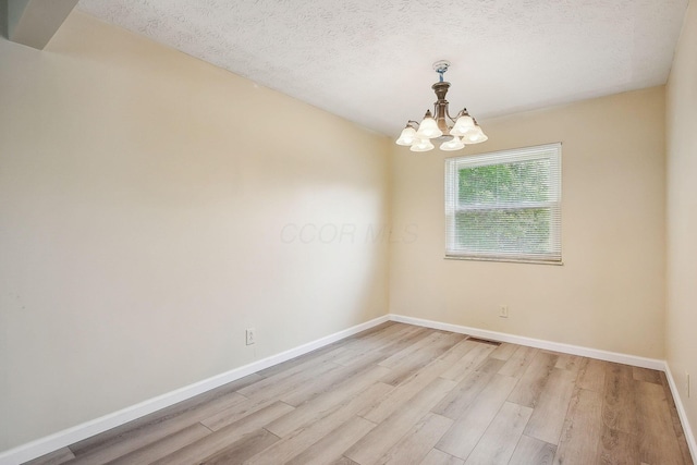 2117 Kilbourne Ave, Columbus, OH 43229 - unfurnished room featuring a chandelier, baseboards, light wood-type flooring, and a textured ceiling