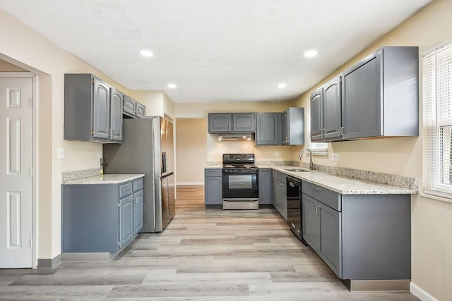 2117 Kilbourne Ave, Columbus, OH 43229 - kitchen featuring black appliances, a sink, under cabinet range hood, baseboards, and gray cabinets