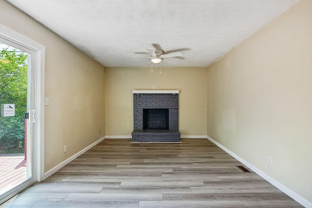 2117 Kilbourne Ave, Columbus, OH 43229 - unfurnished living room with a ceiling fan, wood finished floors, a textured ceiling, a fireplace, and baseboards