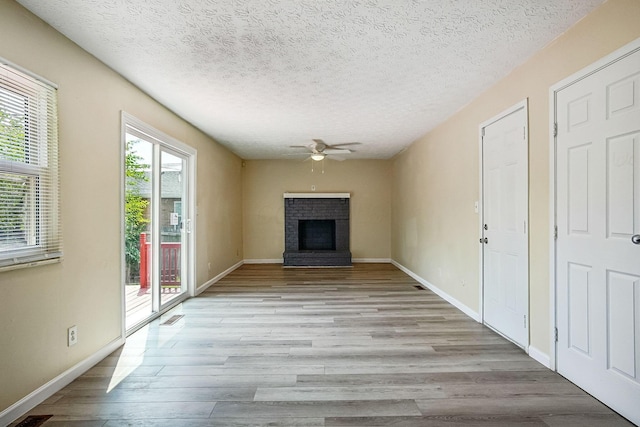 2117 Kilbourne Ave, Columbus, OH 43229 - unfurnished living room with a ceiling fan, a fireplace, light wood-type flooring, a textured ceiling, and baseboards