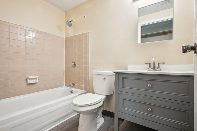 2117 Kilbourne Ave, Columbus, OH 43229 - bathroom with toilet, washtub / shower combination, vanity, wood finished floors, and baseboards