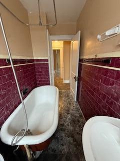 865 E Whittier St, Columbus, OH 43206 - bathroom with tile walls, a wainscoted wall, a bath, and toilet