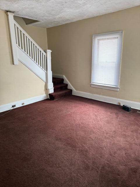 869 E Whittier St, Columbus, OH 43206 - carpeted empty room with stairway, a textured ceiling, and baseboards