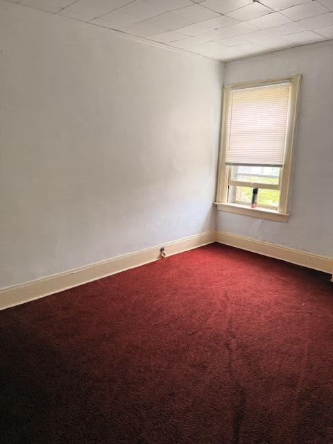 869 E Whittier St, Columbus, OH 43206 - spare room featuring dark colored carpet and baseboards