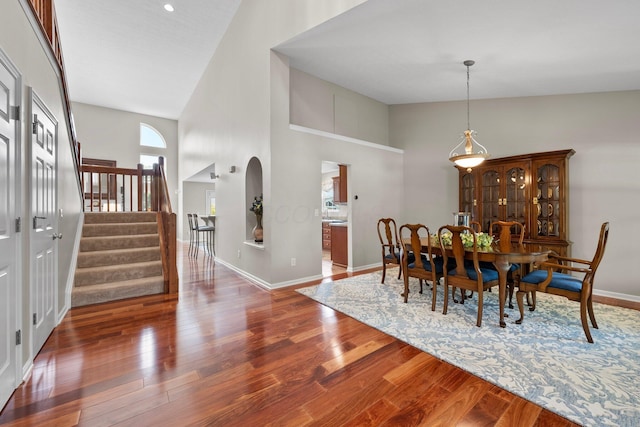 7494 Barrister Dr, Dublin, OH 43016 - dining area with high vaulted ceiling, wood finished floors, stairs, and baseboards