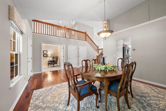 7494 Barrister Dr, Dublin, OH 43016 - dining area with wood finished floors, high vaulted ceiling, stairway, and baseboards