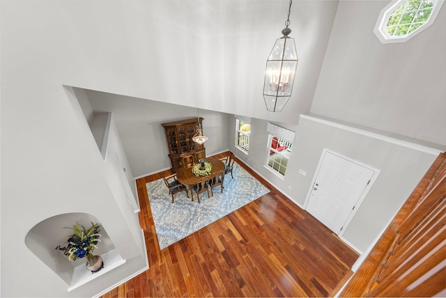 7494 Barrister Dr, Dublin, OH 43016 - dining area featuring a chandelier, a towering ceiling, wood finished floors, and baseboards