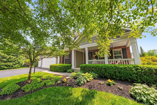 7494 Barrister Dr, Dublin, OH 43016 - view of front facade featuring brick siding, covered porch, asphalt driveway, and an attached garage
