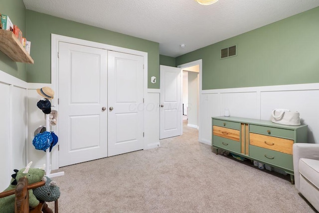 1211 Mcclish Ct, Grove City, OH 43123 - bedroom with wainscoting, carpet flooring, a closet, a textured ceiling, and a decorative wall
