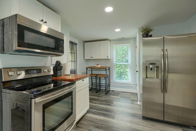 202 Boyleston Ave, Newark, OH 43055 - kitchen with stainless steel appliances, wooden counters, white cabinetry, wood finished floors, and recessed lighting