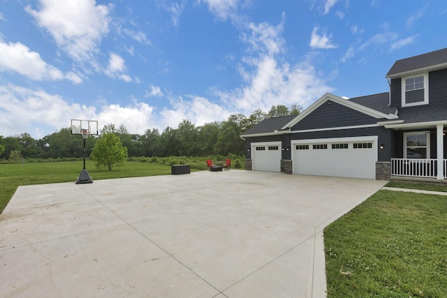 9559 Basil Rd NW, Baltimore, OH 43105 - view of side of home with concrete driveway, a yard, stone siding, and a garage