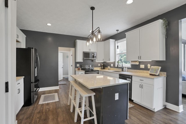 9559 Basil Rd NW, Baltimore, OH 43105 - kitchen with appliances with stainless steel finishes, a sink, dark wood-style flooring, white cabinets, and baseboards