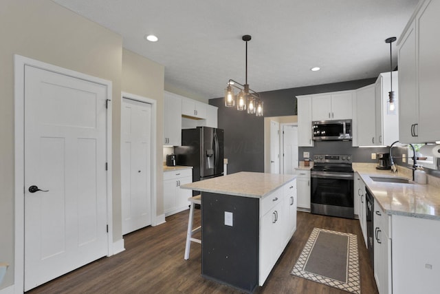 9559 Basil Rd NW, Baltimore, OH 43105 - kitchen with stainless steel appliances, a sink, dark wood finished floors, a kitchen island, and white cabinets